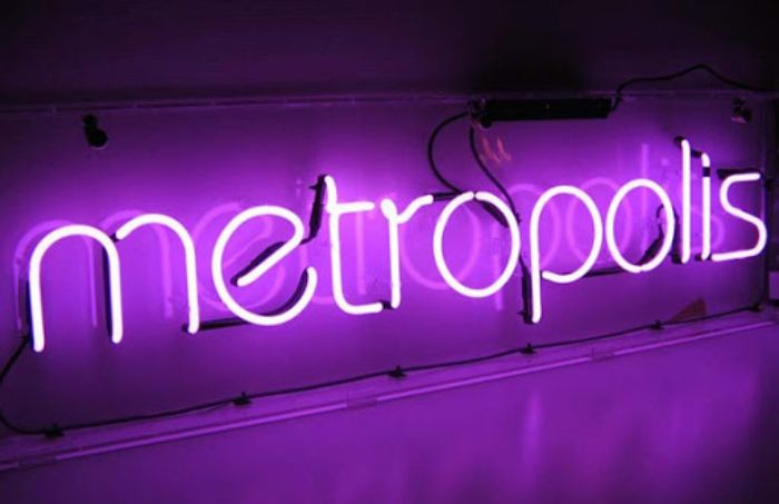 Một chiếc bảng hiệu neon màu tím cũng dòng chữ có thiết kế đơn giản