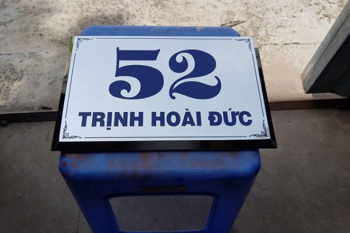 Bảng hiệu chỉ địa chỉ có nền bạc và chữ màu xanh đậm